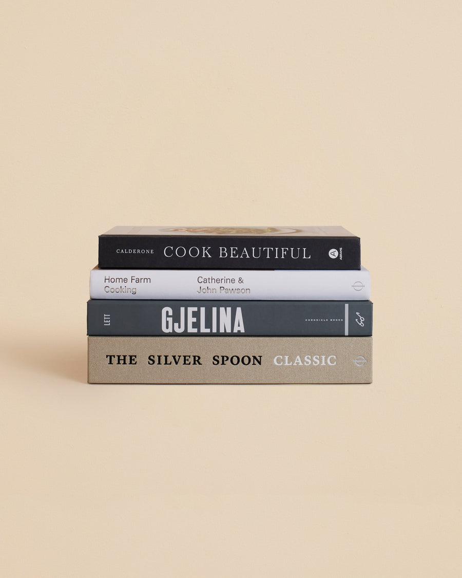 four book stack of books about gourmet cooking in a neutral color palette