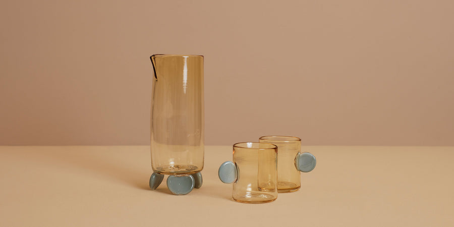 artisanal hand blown footed glass carafe and two glasses with handles in whiskey and grey colors