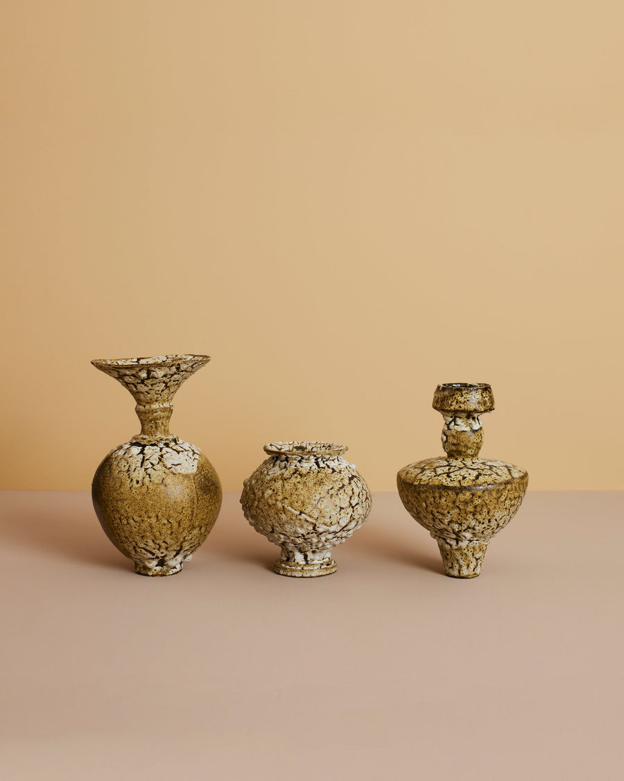 stylized image of mediterranean handmade glazed green-toned unique stoneware vases with cream colored textured glazing