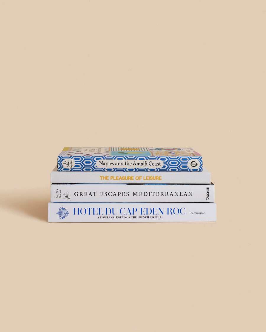 The Escape Book Stack by Maison Plage for Arjé, four blue and white travel books on Naples, the Amalfi Coast, the Mediterranean and Hôtel du Cap-Eden-Roc