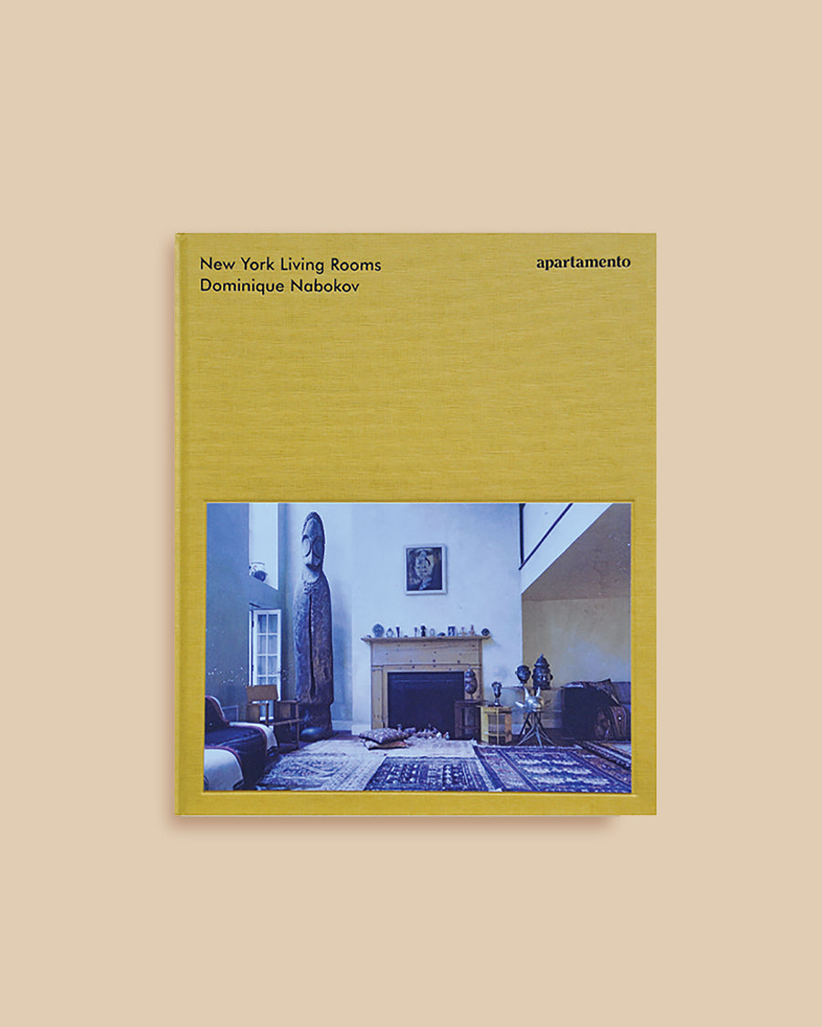 Hardcover yellow coffee table book with a New York living room photograph