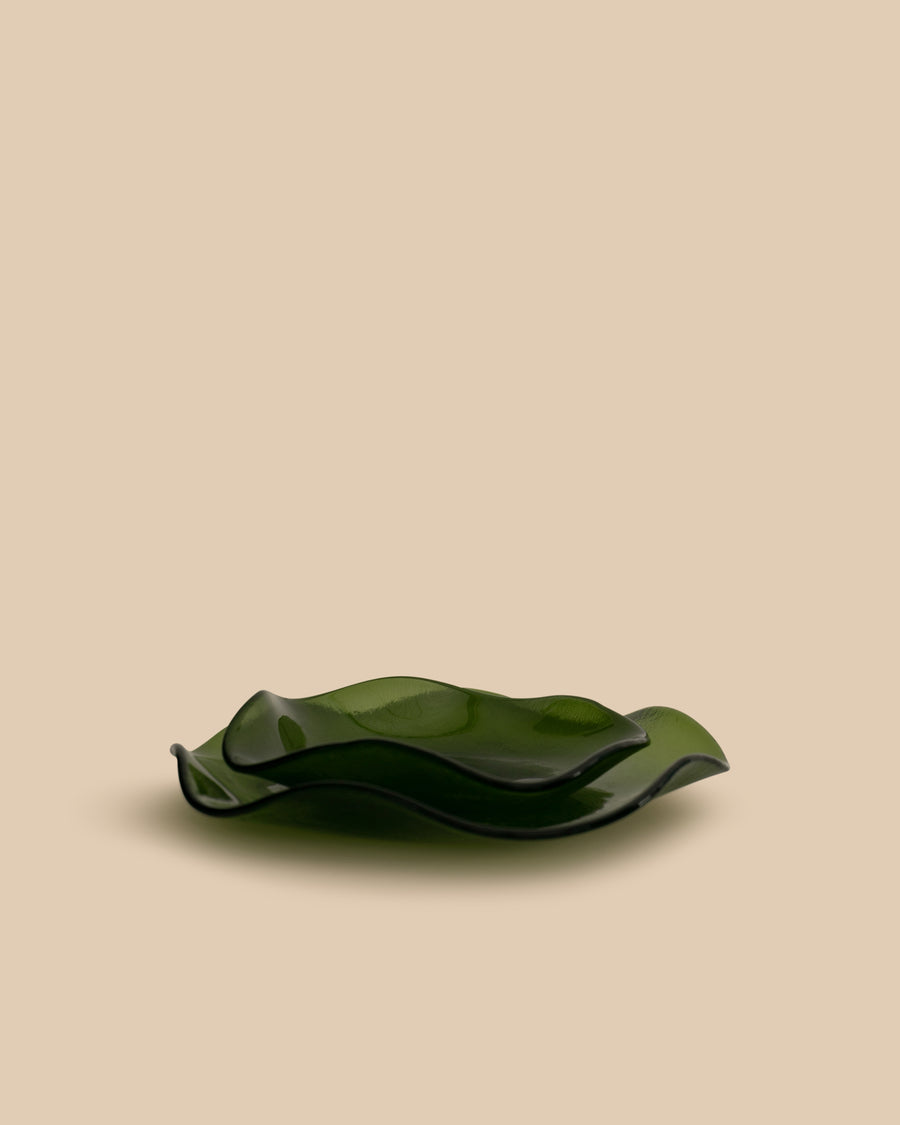 A large, hand-crafted glass plate in an elegant olive green shade with a soft, wavy petal design on the edges, perfect for serving or as a decorative piece.