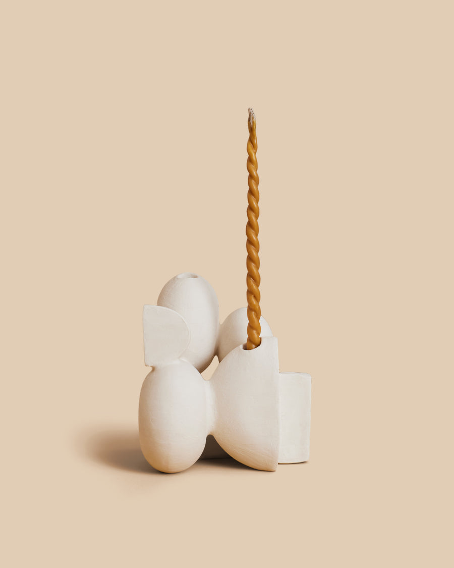 Velas N.23 by Re Jin Lee, a white ceramic candle holder of stacked rounded forms, shown holding a single twisted taper