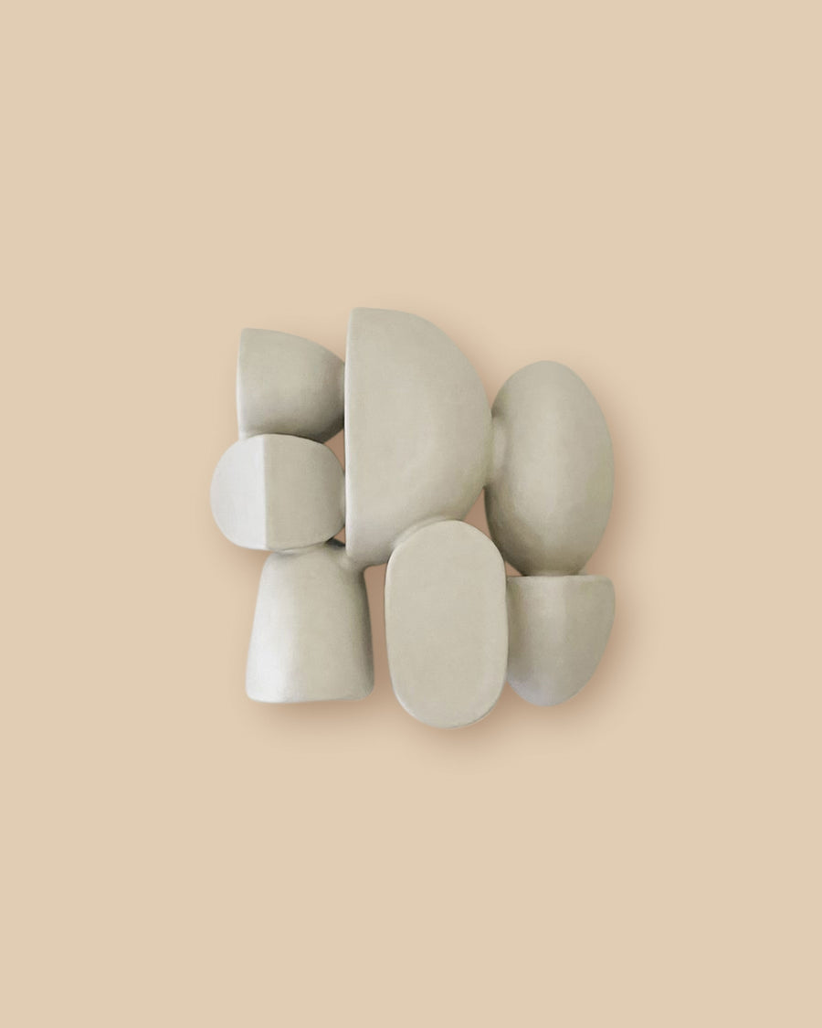 Unique white sculptural wall art with circular ceramic forms.