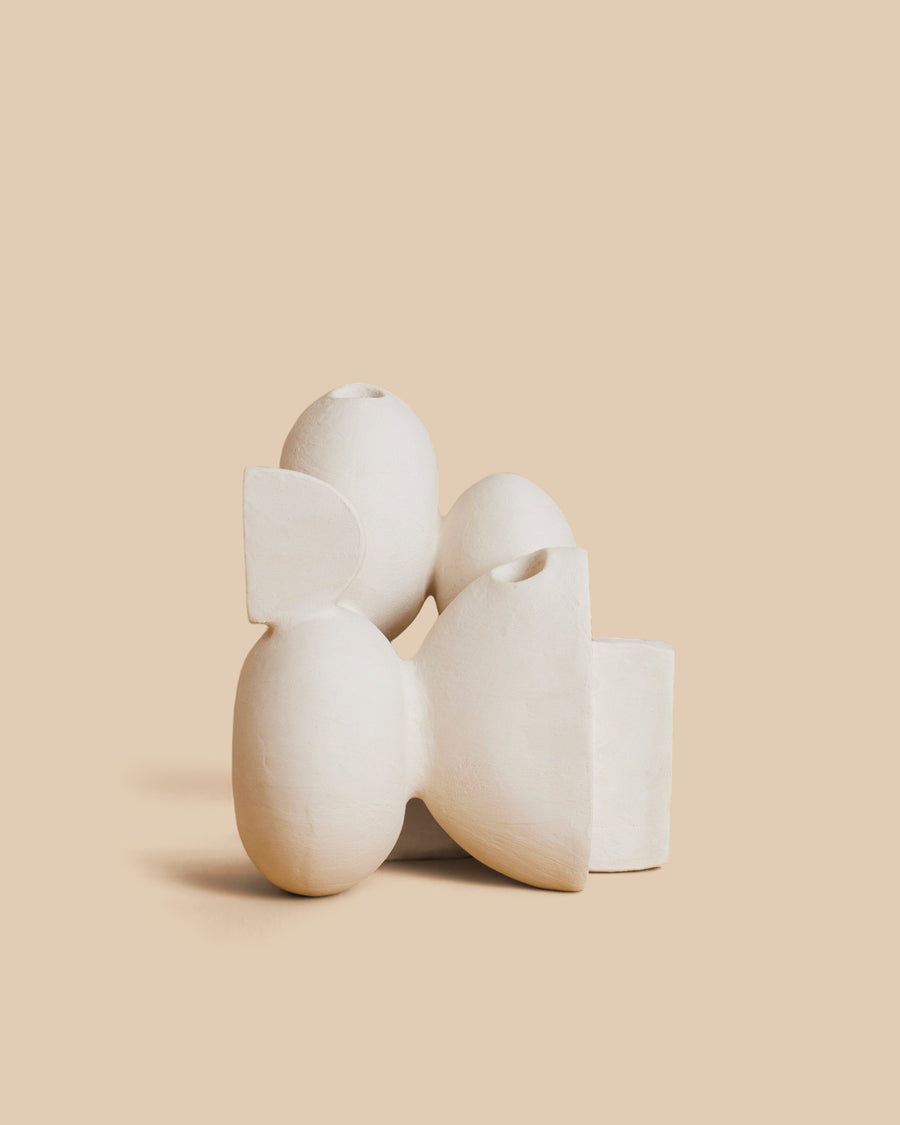 Velas N.23 by Re Jin Lee, a white ceramic candle holder of stacked rounded forms, shown holding a single twisted taper