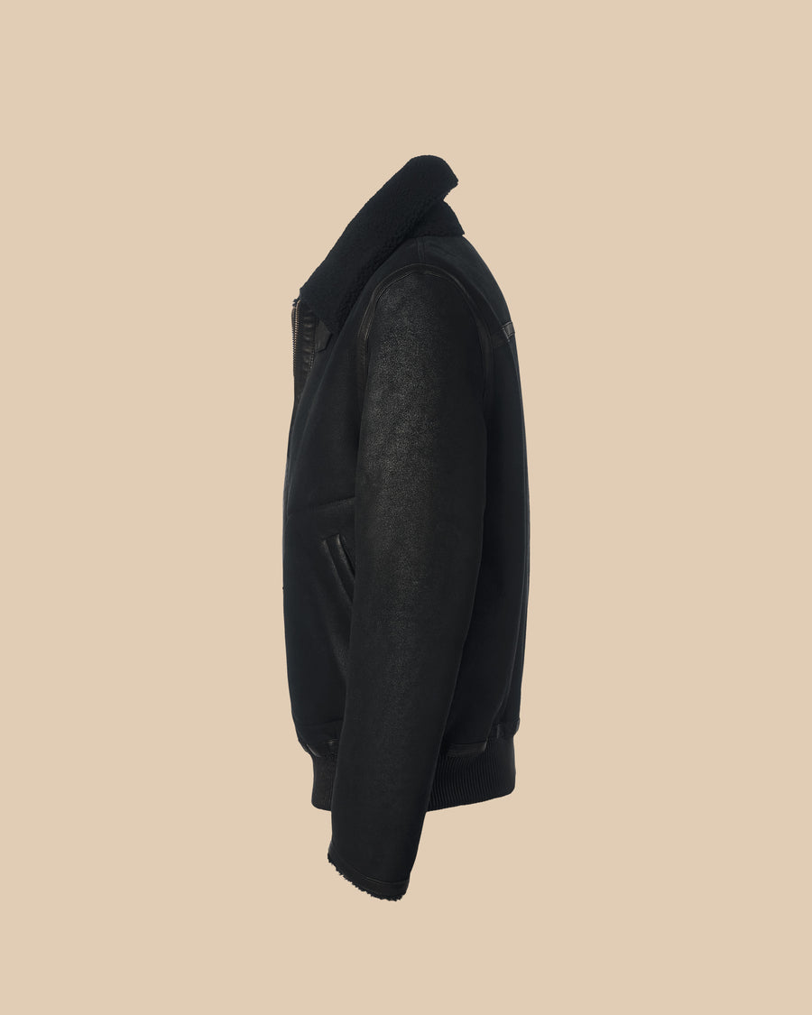 black reversible classic shearling aviator jacket with elastic trim at hem and buckles at the turtleneck collar