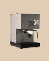 modern sleek concrete espresso machine appliance with wood portafilter, brass fittings, glass water tank, porcelain steam knob side view