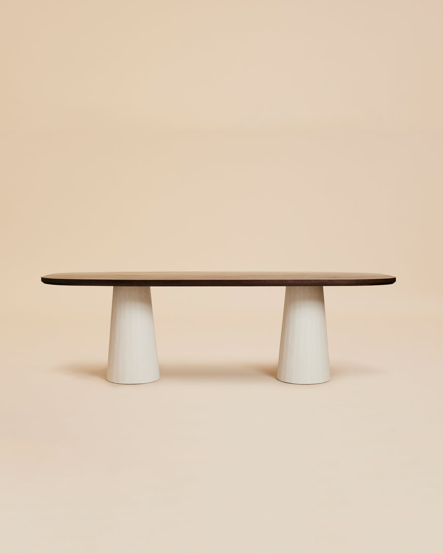 stylized image of modern walnut oval dining table with ivory cylindrical plaster legs
