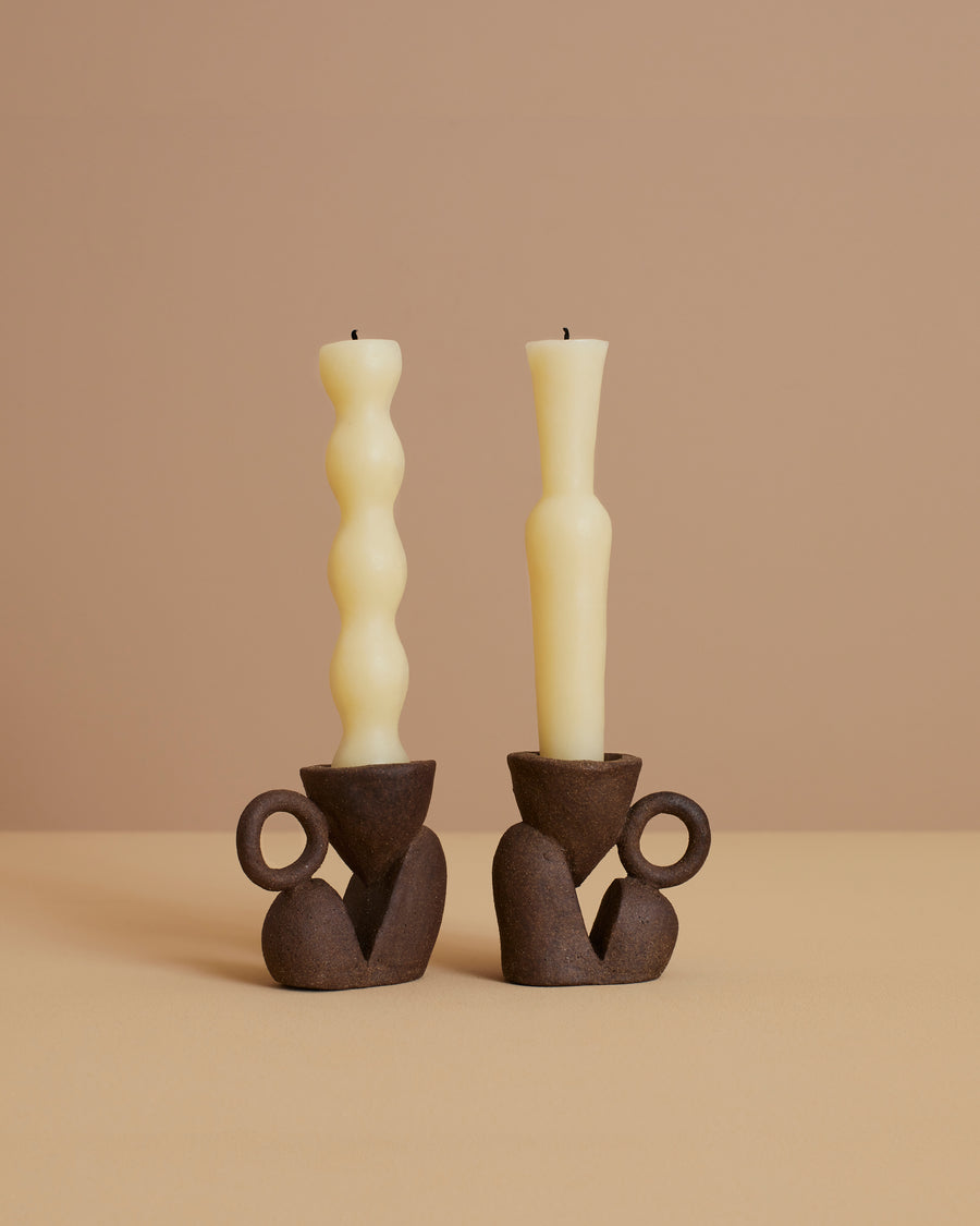 set of two dark brown sculptural stoneware candlestick holders with handmade beeswax candles