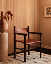 stylized image of turned walnut wood accent armchair with cognac leather sling seat and backrest