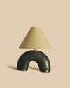 handmade rustic navy blue ceramic table lamp in a half circle-shaped base with parchment shade